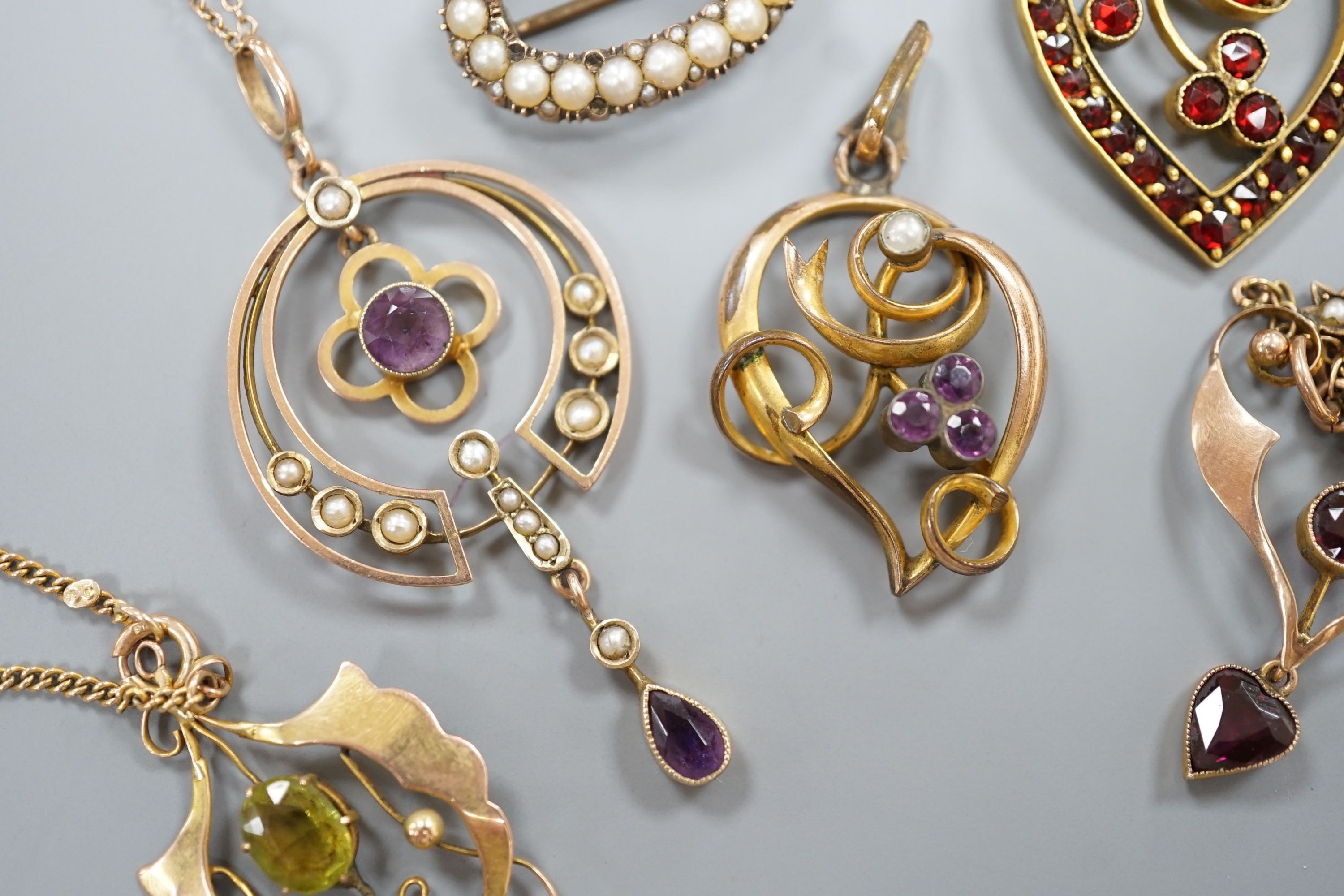 Three early 20th century yellow metal and gem set drop pendants, including two stamped 9ct and two with 9ct chains, largest 5cm, gross weight 10.1 grams, two other pendants and a yellow metal and split pearl set oval bro